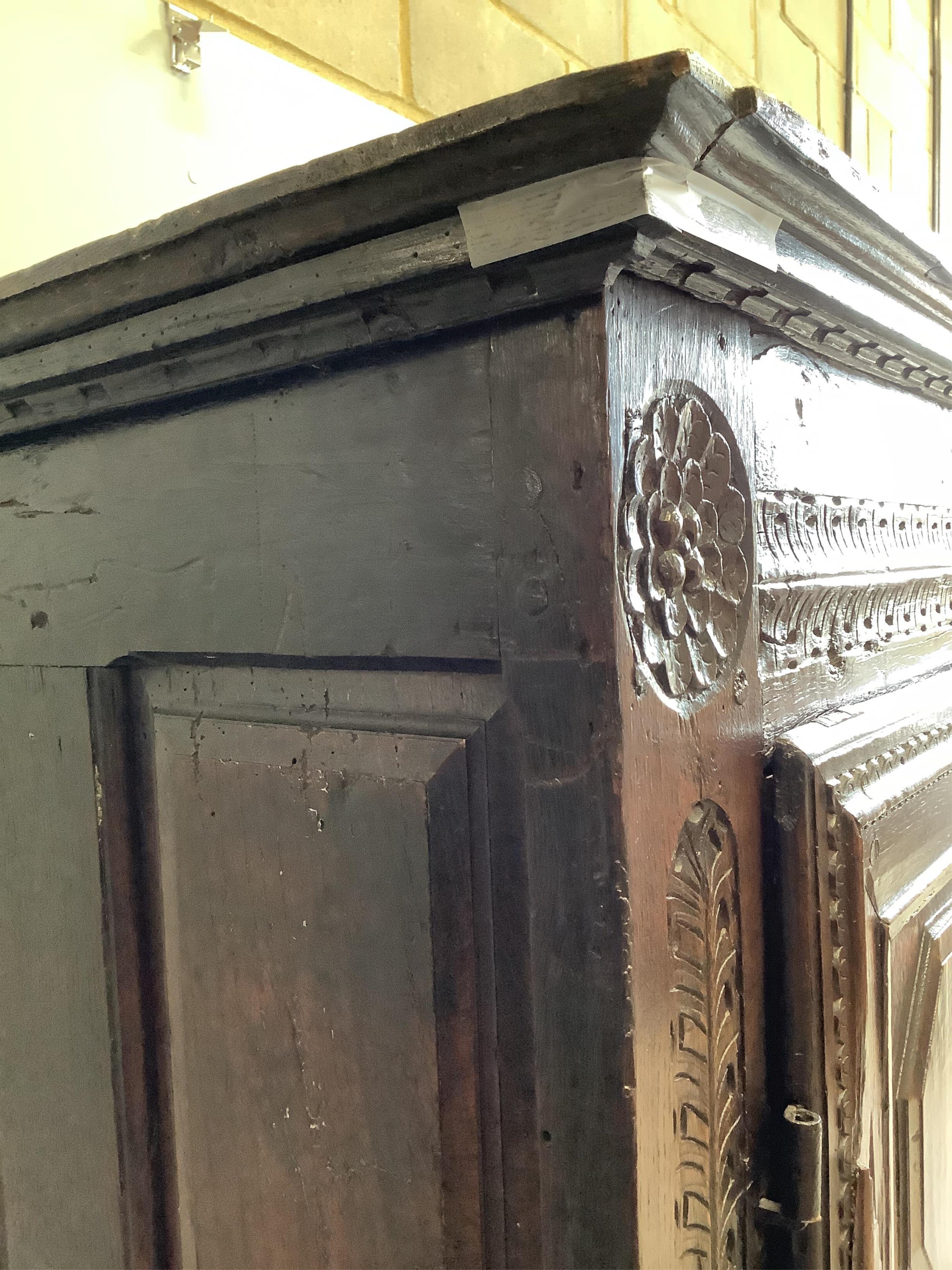 An early 18th century continental panelled oak cupboard bearing date 1701, width 130cm, height 193cm. Condition - fair, cornice detached, lacks inner shelves